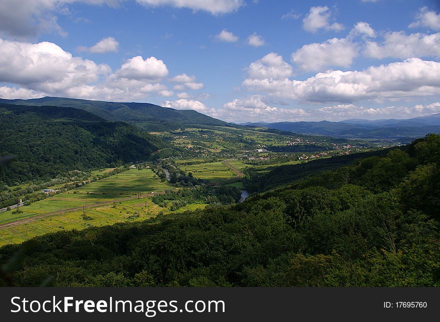 Summer landscape of mountain valleys shrouded in thick forests