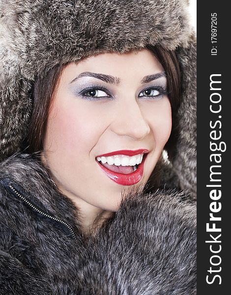 Portrait of young beautiful woman in a fur coat and hat