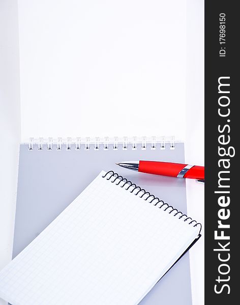 A red pen on a notebook, isolated in white background.