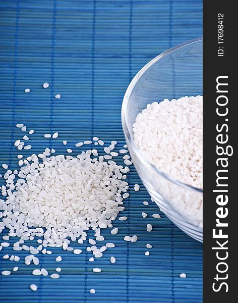 White rice in a glass dish on blue background