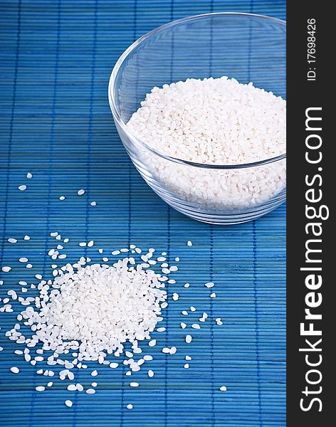 White rice in a glass dish on blue background