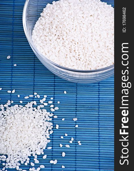 White rice in a glass dish on blue background