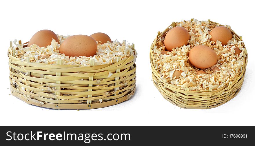 Three chicken eggs in a straw basket with wood shreds to remove humidity. Three chicken eggs in a straw basket with wood shreds to remove humidity.