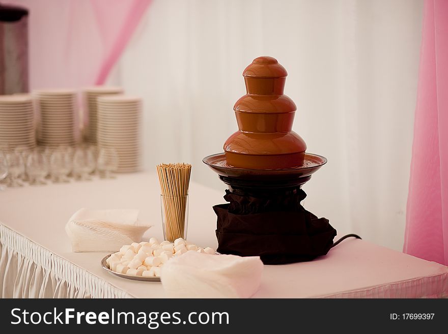 A chocolate fountain for desserts in a restaurant during a wedding feast