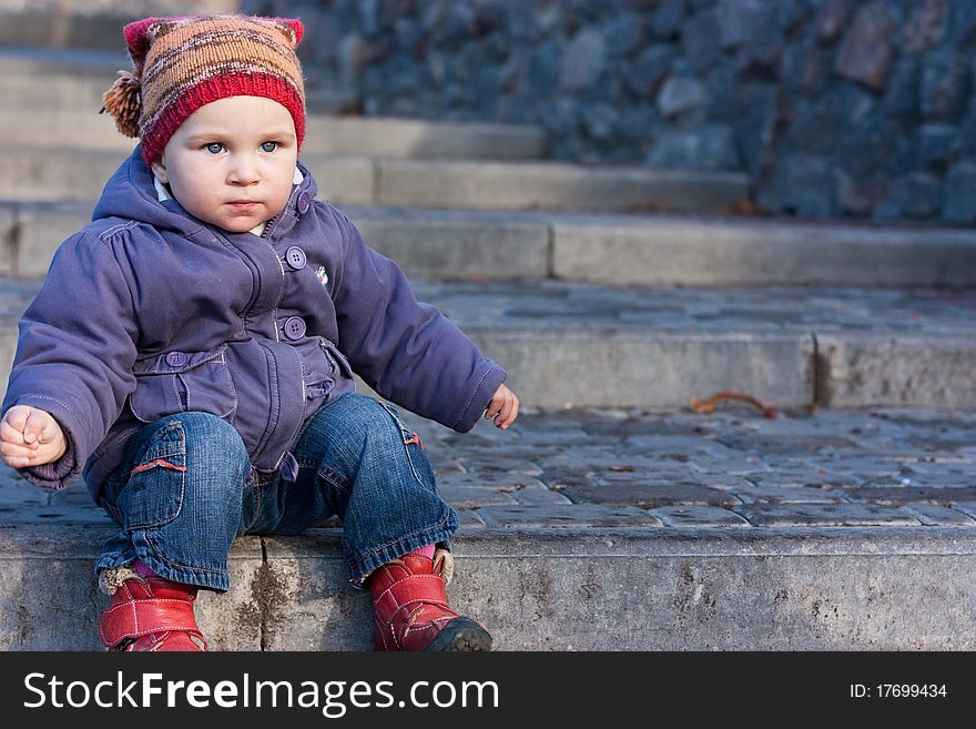 Beautiful baby sitting on stairs outdoor