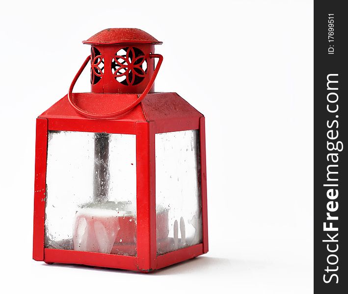 A small red colored candle lantern, that is more practical to place than a lone candle