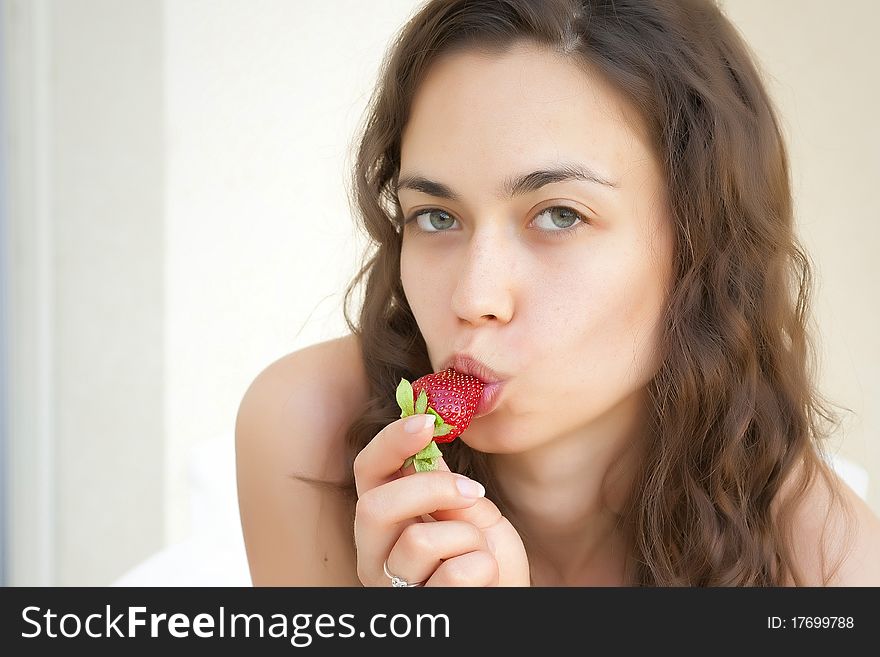 The girl the brunette eats an appetizing berry a s