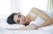 Pretty Woman Lying Down On Her Bed At Home Royalty Free Stock Images