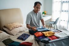 Young Man Preparing Her Clothes Put In The Suitcase Royalty Free Stock Image