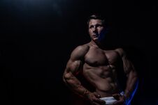 Muscular Man Showing Muscles Isolated On The Black Background. Concept Of Healthy Lifestyle And Healthcare Royalty Free Stock Photos