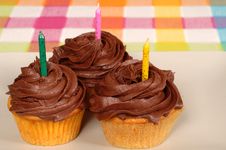 Three Chocolate Frosted Cupcakes With Candles Royalty Free Stock Photos Three Chocolate Frosted Cupcakes With Candles Royalty Free Stock Photos