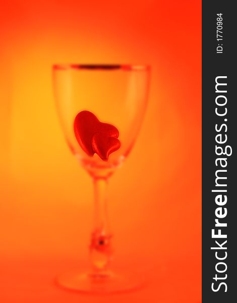 Abstract blurred picture of a glass filled with two little hearts. Abstract blurred picture of a glass filled with two little hearts