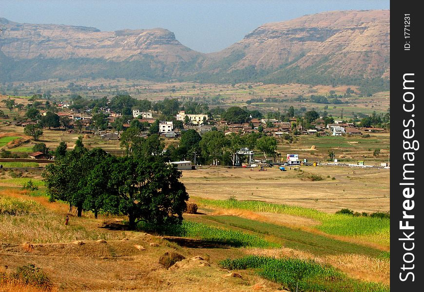 A distant Indian village landscape having trees,houses,fields and farms. A distant Indian village landscape having trees,houses,fields and farms.