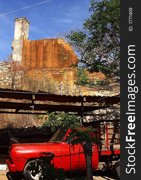 Typical colonial house semi abandoned with red truck in the town of Alamos, in the northern state of Sonora, Mexico, Latin America