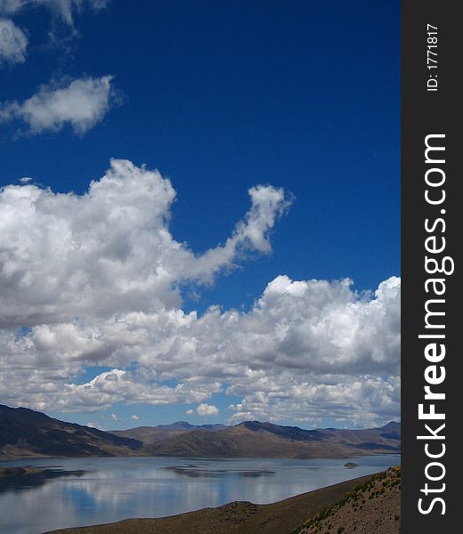 Blue Puffy Clouds  reflected in lake. Blue Puffy Clouds  reflected in lake