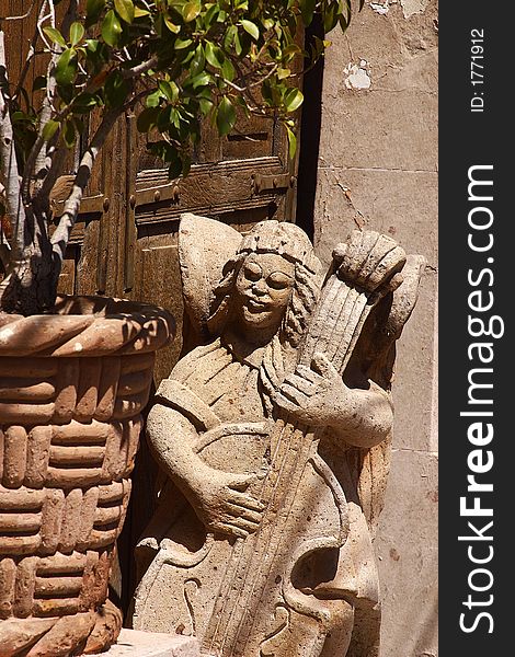 Detail of a playinf angel made of stone inf ront of a colonial house in the town of Alamos in the northern state of Sonora, Mexico, Latin America