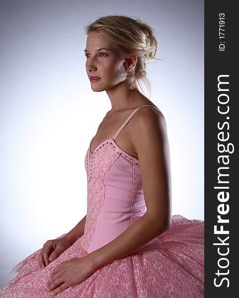 Ballerina with pink resting hands on tutu bottom and looking ahead. Ballerina with pink resting hands on tutu bottom and looking ahead