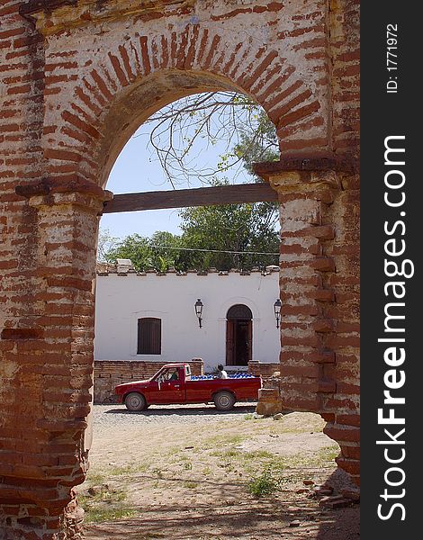 Old arch of an abandoned house and a typical street with truck in the town of Alamos in the northern state of Sonora in Mexico, Latin America