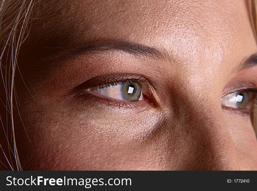 Closeup of eye of a beautiful blond girl looking to the right of camera. Closeup of eye of a beautiful blond girl looking to the right of camera