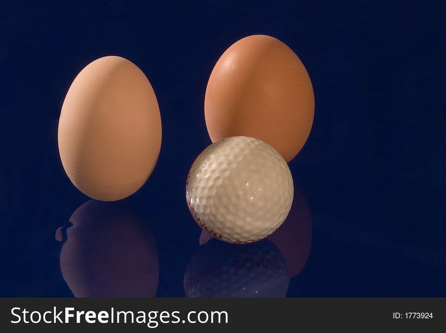 Eggs with golf ball on dark blue background
