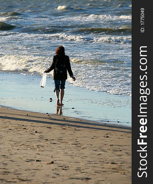 The barefooted girl collects amber on seacoast. The barefooted girl collects amber on seacoast