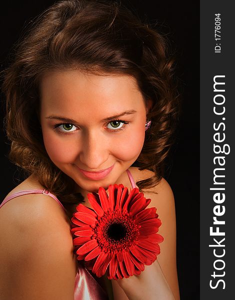 Pretty girl with red flower on black background