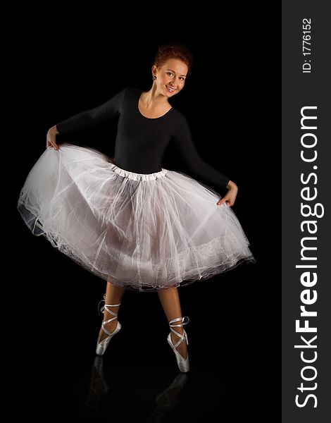 Beautiful girl ballerina to be on points on black background