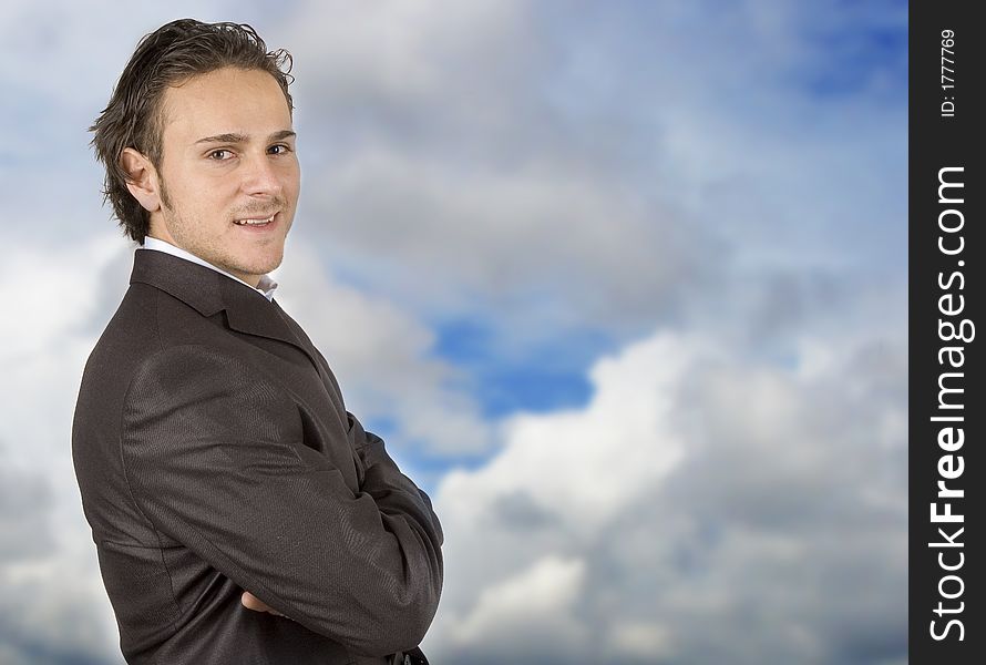 Businessman posing against the sky in sleek outfit