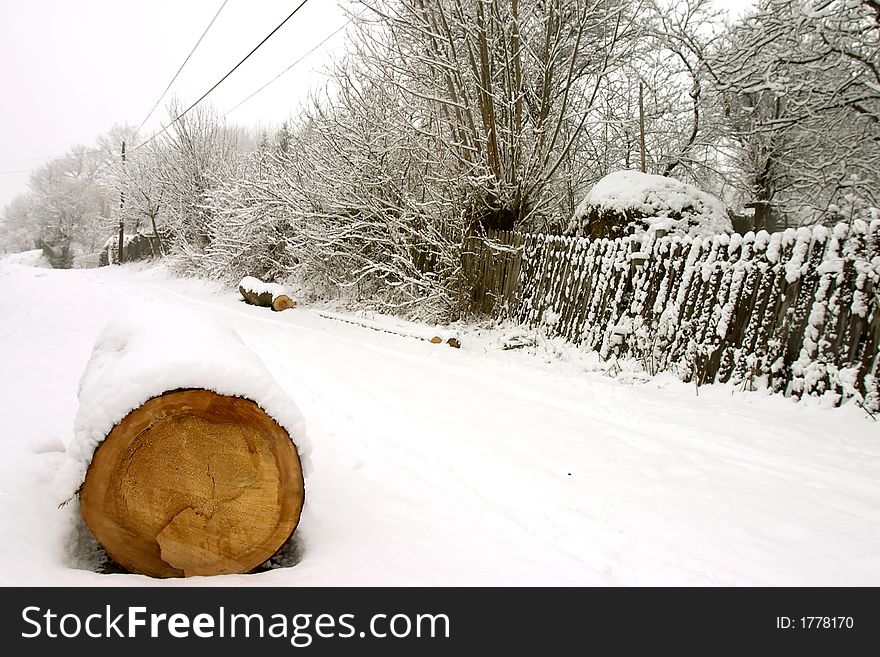 Wood log covered by snow on road. Wood log covered by snow on road