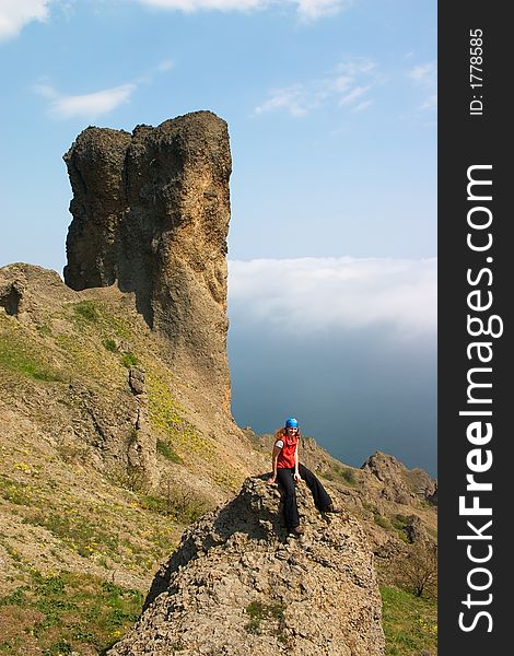 Girl sitting alone on the rock in the mountains. Girl sitting alone on the rock in the mountains