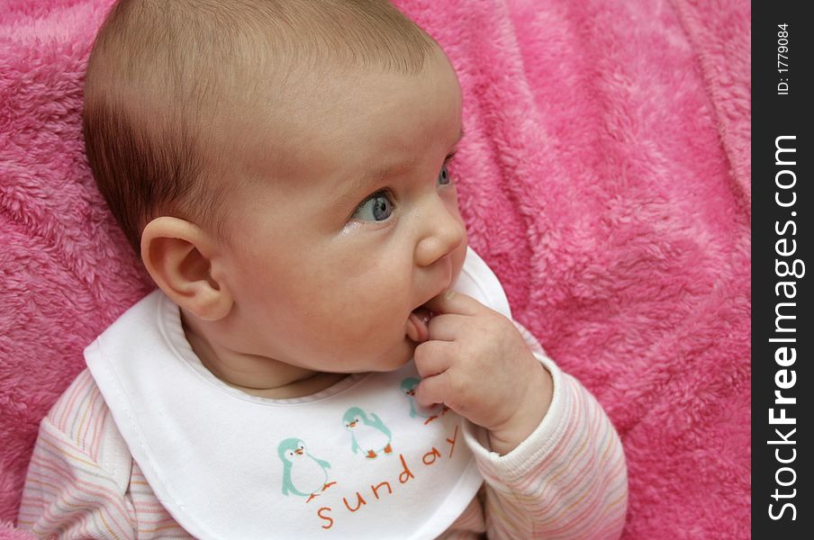 A baby on a pink blanket. A baby on a pink blanket