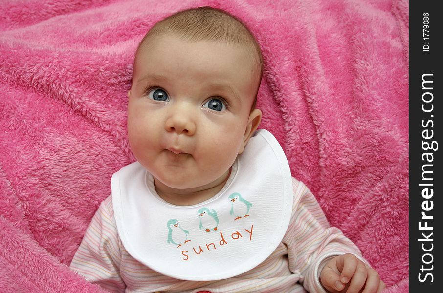 A baby on a pink blanket. A baby on a pink blanket