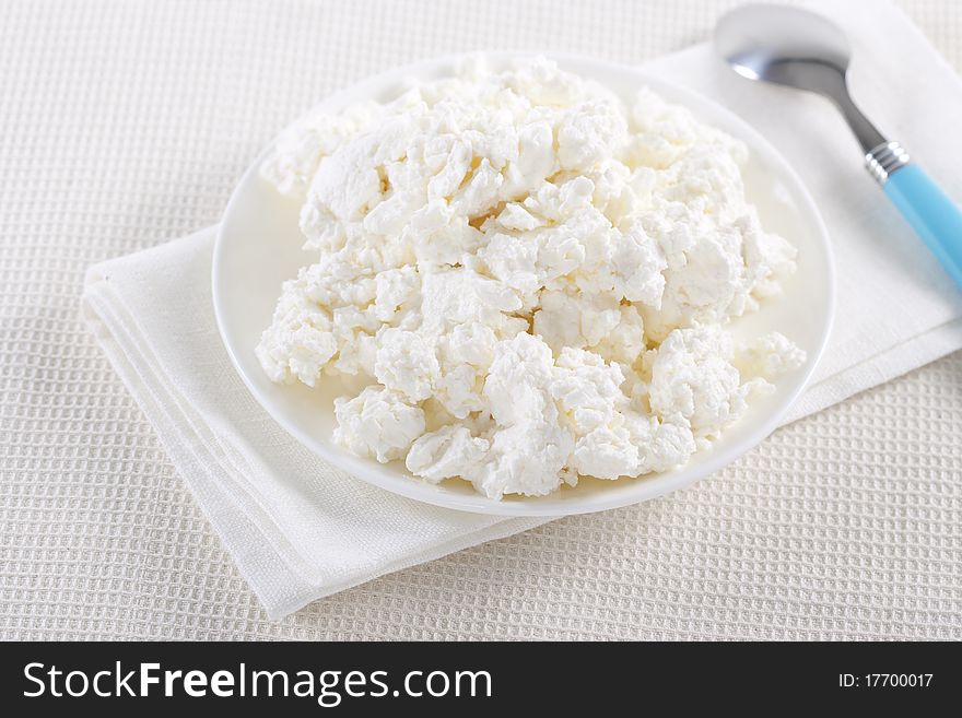 Fresh cottage cheese on the white plate