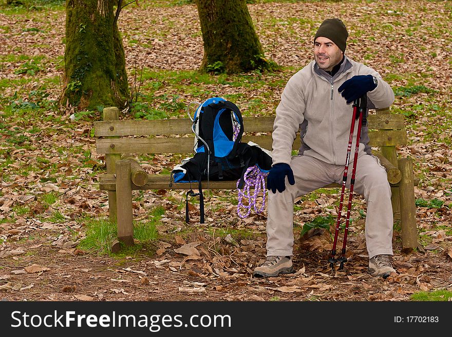 Hiker resting on a forest park bench. Hiker resting on a forest park bench