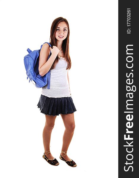A pretty teenager in a short skirt and a blue backpack over her shoulder standing in the studio for white background. A pretty teenager in a short skirt and a blue backpack over her shoulder standing in the studio for white background.