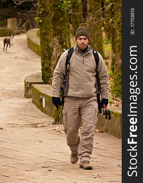 Hiker walking in a man made trail, with backpack and gear