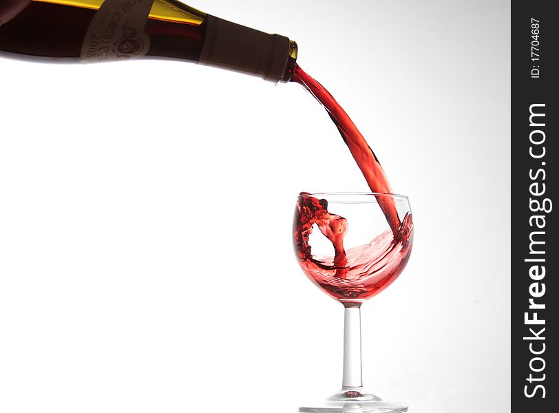 Red wine being poured in to a glass, isolated on white. Red wine being poured in to a glass, isolated on white.