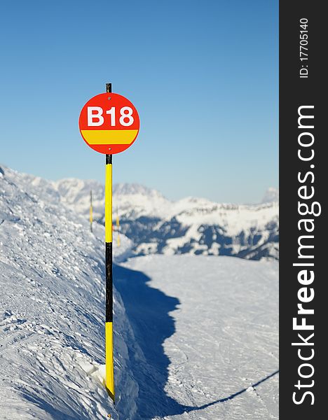 Route index on red round sign with yellow and black stick placed in mountains of Austria. Route index on red round sign with yellow and black stick placed in mountains of Austria