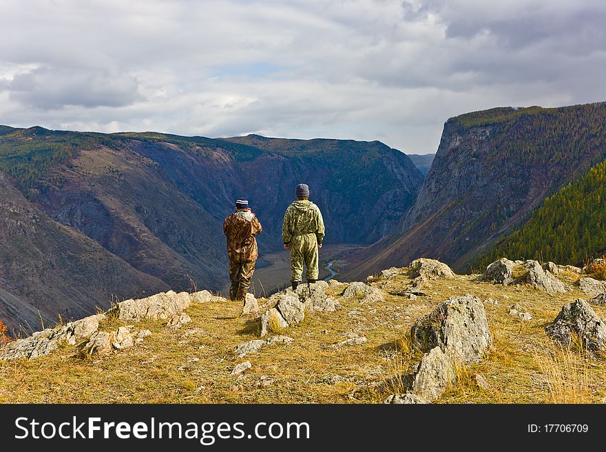 Tourists at precipice in mountains, Altai, Siberia, Russia. Tourists at precipice in mountains, Altai, Siberia, Russia