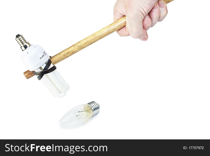 Male hand breaks old electric light bulb with hammer made modern fluorescent bulb isolated on white as energy saving concept. Male hand breaks old electric light bulb with hammer made modern fluorescent bulb isolated on white as energy saving concept