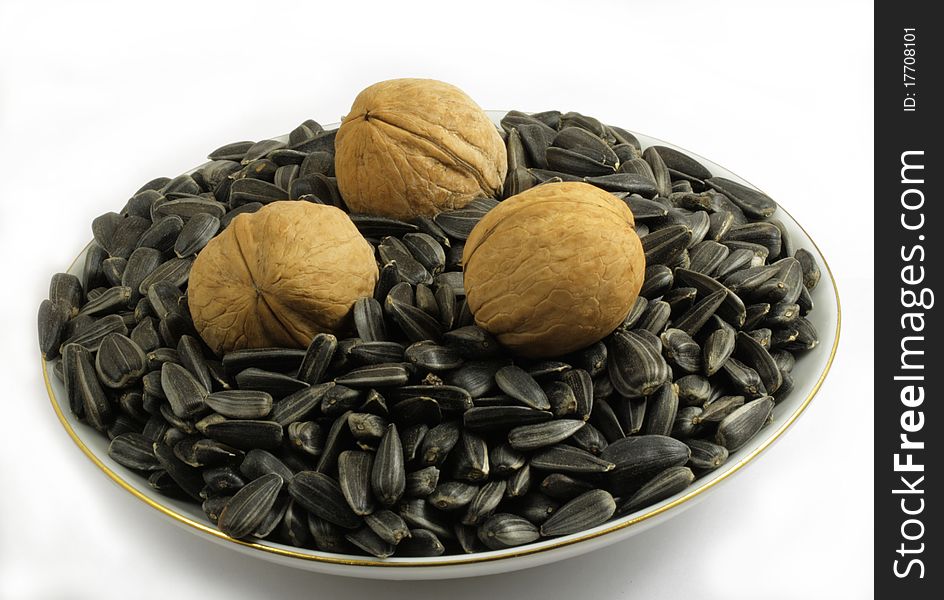 Three walnuts and sunflower seeds on a saucer