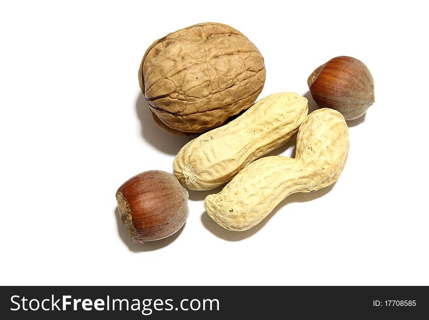 A lot of nuts, peanuts and a walnut in a white background. A lot of nuts, peanuts and a walnut in a white background