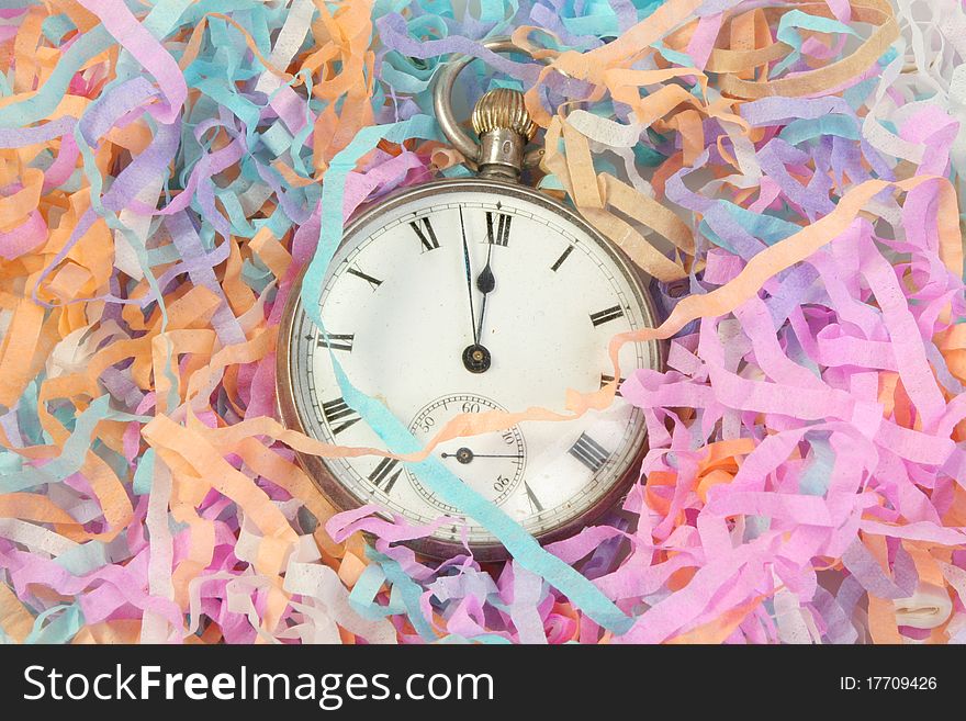 Antique pocket watch near midnight surrounded by party streamers. Antique pocket watch near midnight surrounded by party streamers