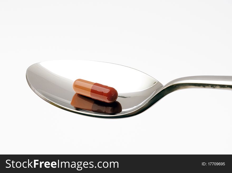 A spoon with a pill