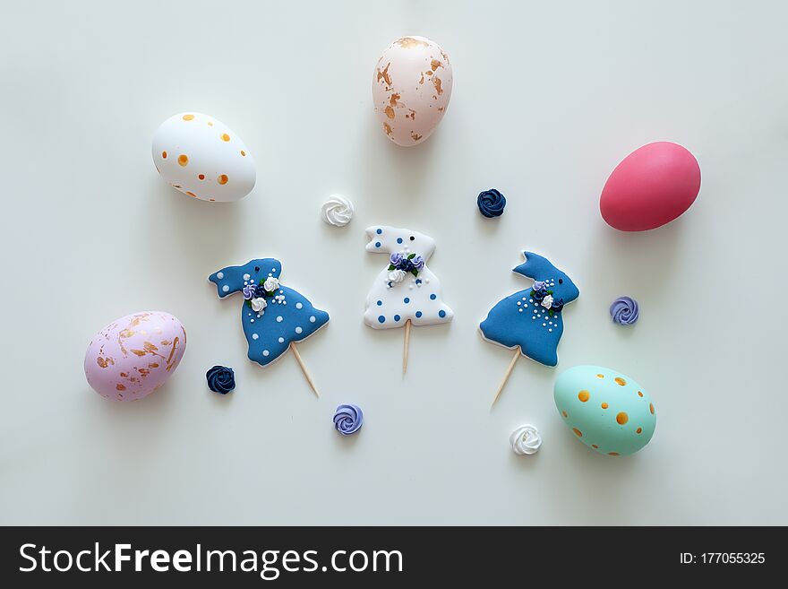 Homemade easter cookies in shape of funny bunny and multicolored eggs on white background. Easter celebration. Holiday decorations. Decorated Easter Cookies rabbits in icing. Easter baking. Flat lay