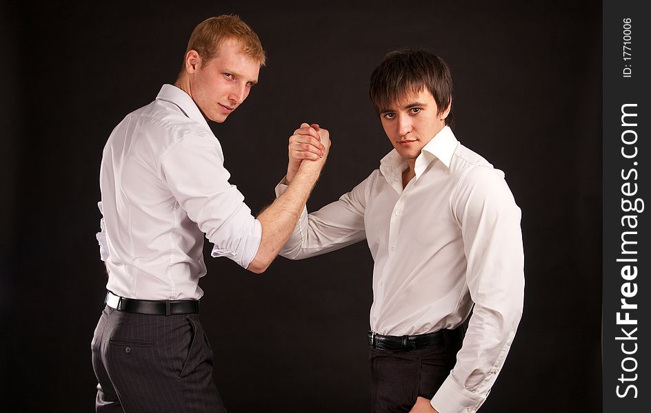 Portrait two adult man in business hand shake on black backdrop