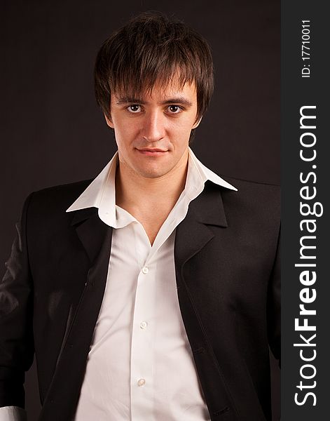 Portrait strong adult man with charming sight on a black backdrop