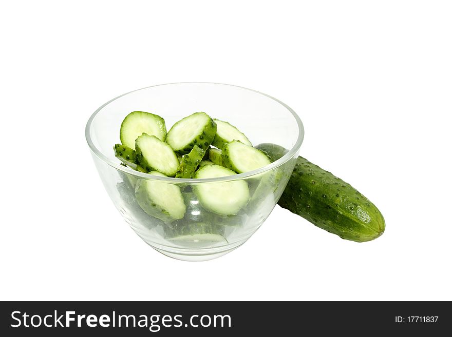 Slices of cucumber in a glass bowl on white background