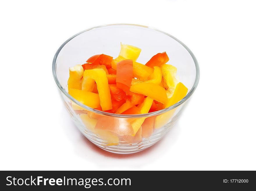 Slices of yellow pepper in a glass bowl on white background