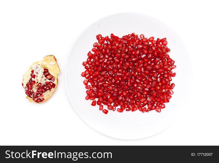 Red pomegranate seeds on a plate, and peeled fruit